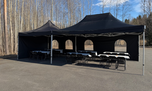 4x10m musta juhlateltta asfaltoidulla pihamaalla.